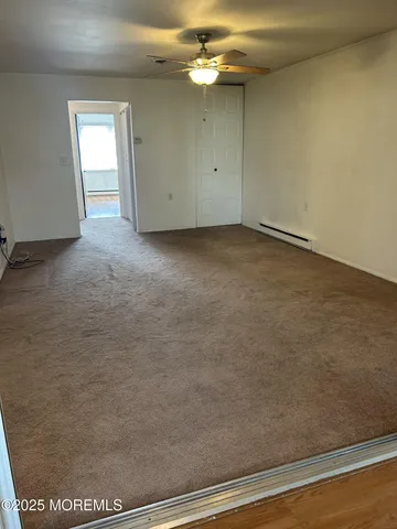 an empty room with a ceiling fan and window