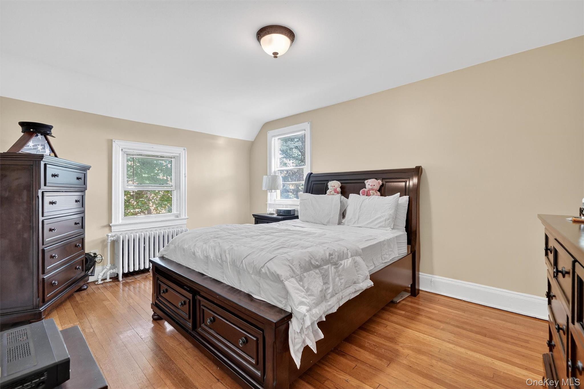 3384 Country Club Road Bronx, NY 10465 - Photo 28 of 48 Bedroom with light wood finished floors, radiator heating unit, and lofted ceiling
