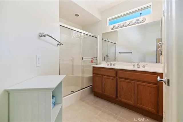 a bathroom with a double vanity sink mirror and shower