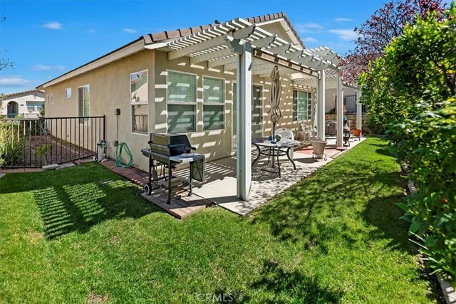 a view of a chair and table in backyard of the house