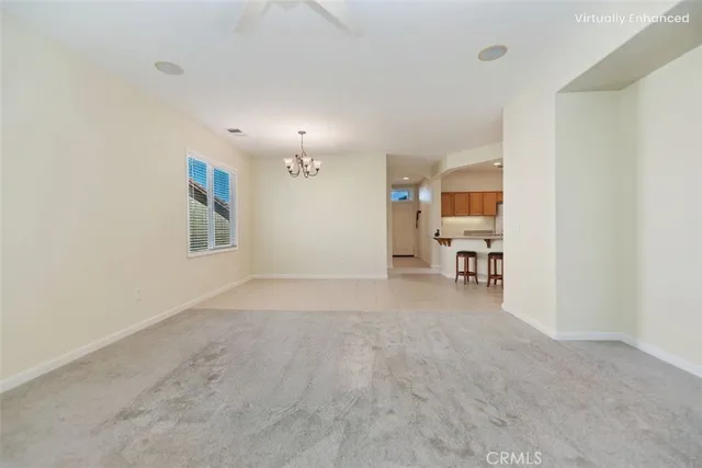 an empty room with kitchen view and a window