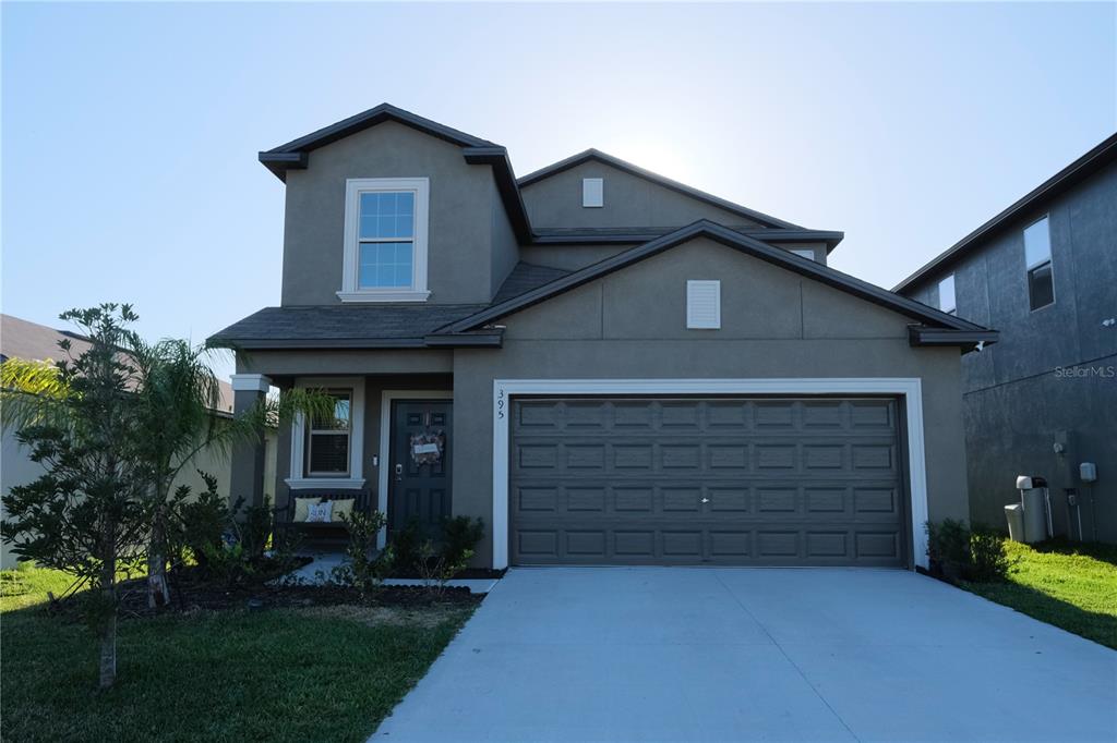 a front view of a house with a yard and garage