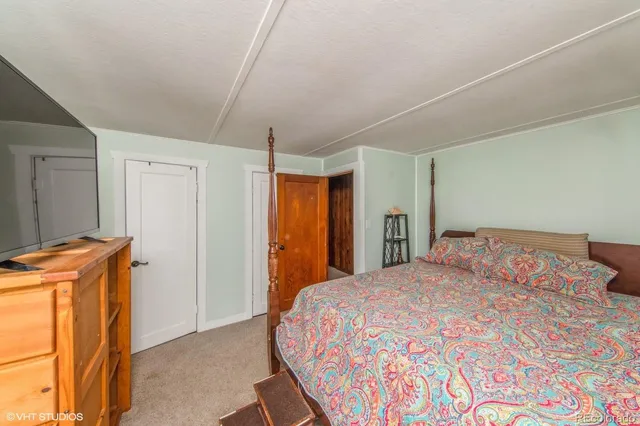 a bedroom with a bed and a refrigerator