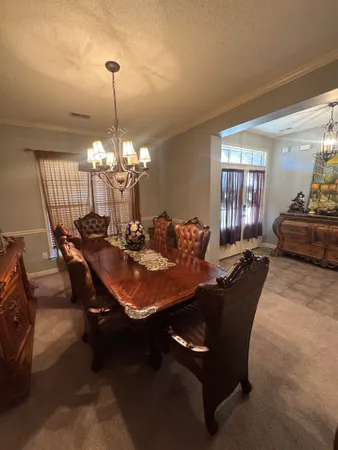 a dining room with furniture a chandelier and window