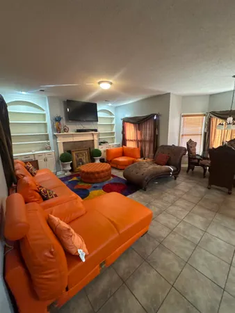 a living room with furniture a fireplace and large windows