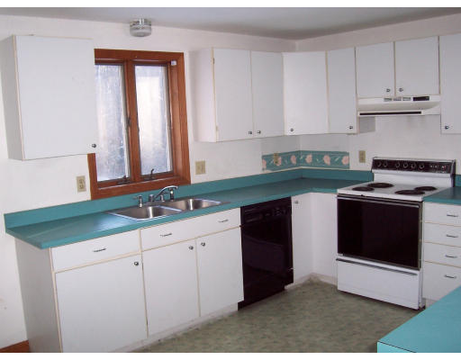 100 Eagleville Road Orange, MA 01364 - Photo 6 of 7 a kitchen with granite countertop white cabinets and white appliances