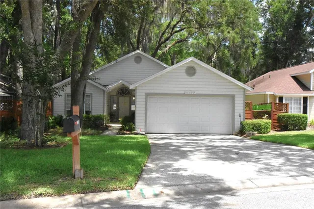 a front view of a house with a yard and trees