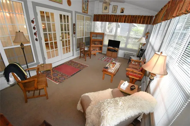 a living room with furniture floor to ceiling window and a flat screen tv