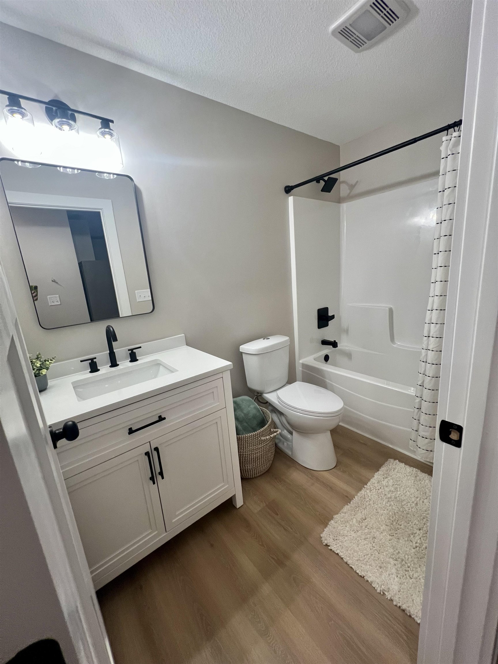 1006 26th Street, Unit B Cloquet, MN 55720 - Photo 12 of 27 Bathroom featuring vanity, light wood finished floors, a textured ceiling, and shower / tub combo