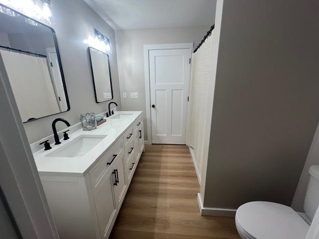 1006 26th Street, Unit B Cloquet, MN 55720 - Photo 18 of 27 Full bathroom with double vanity, a shower with shower curtain, and dark wood-type flooring