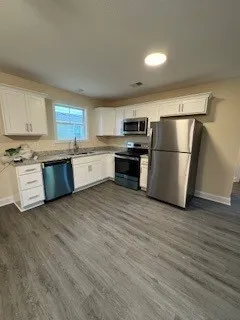 a kitchen with a refrigerator a stove top oven a sink and dishwasher