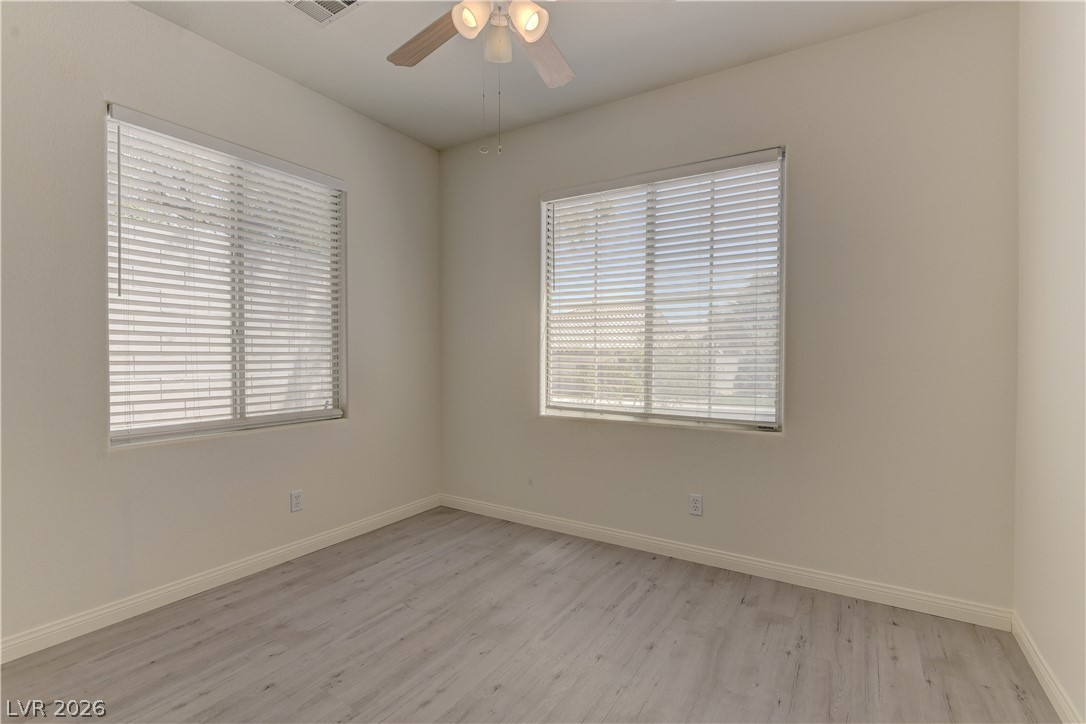 4613 Rising Cove Street Las Vegas, NV 89129 - Photo 8 of 20 This spacious bedroom offers ample light and modern flooring, creating a versatile living space.