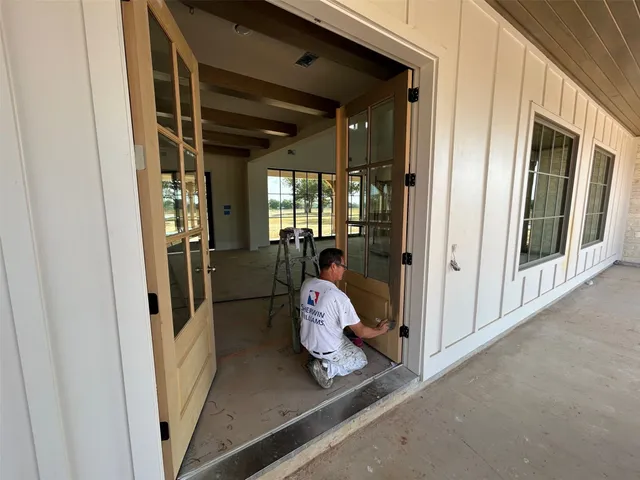 a view of a house with a yard potted plants and a large tree