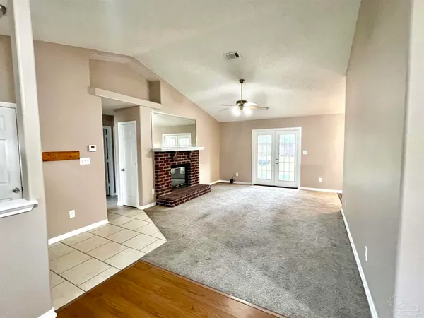 an empty room with fireplace and windows