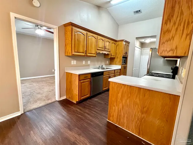 a kitchen with stainless steel appliances granite countertop a sink and a refrigerator