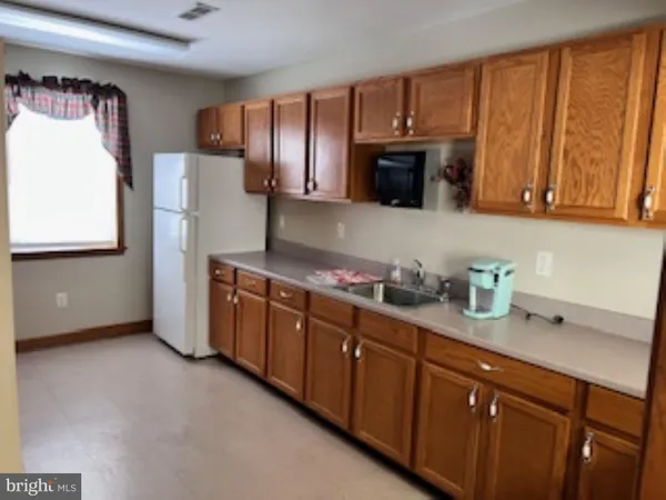 a kitchen with refrigerator a microwave a sink and cabinets