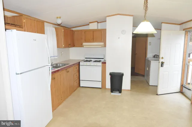 a kitchen with a refrigerator a stove top oven a sink and dishwasher