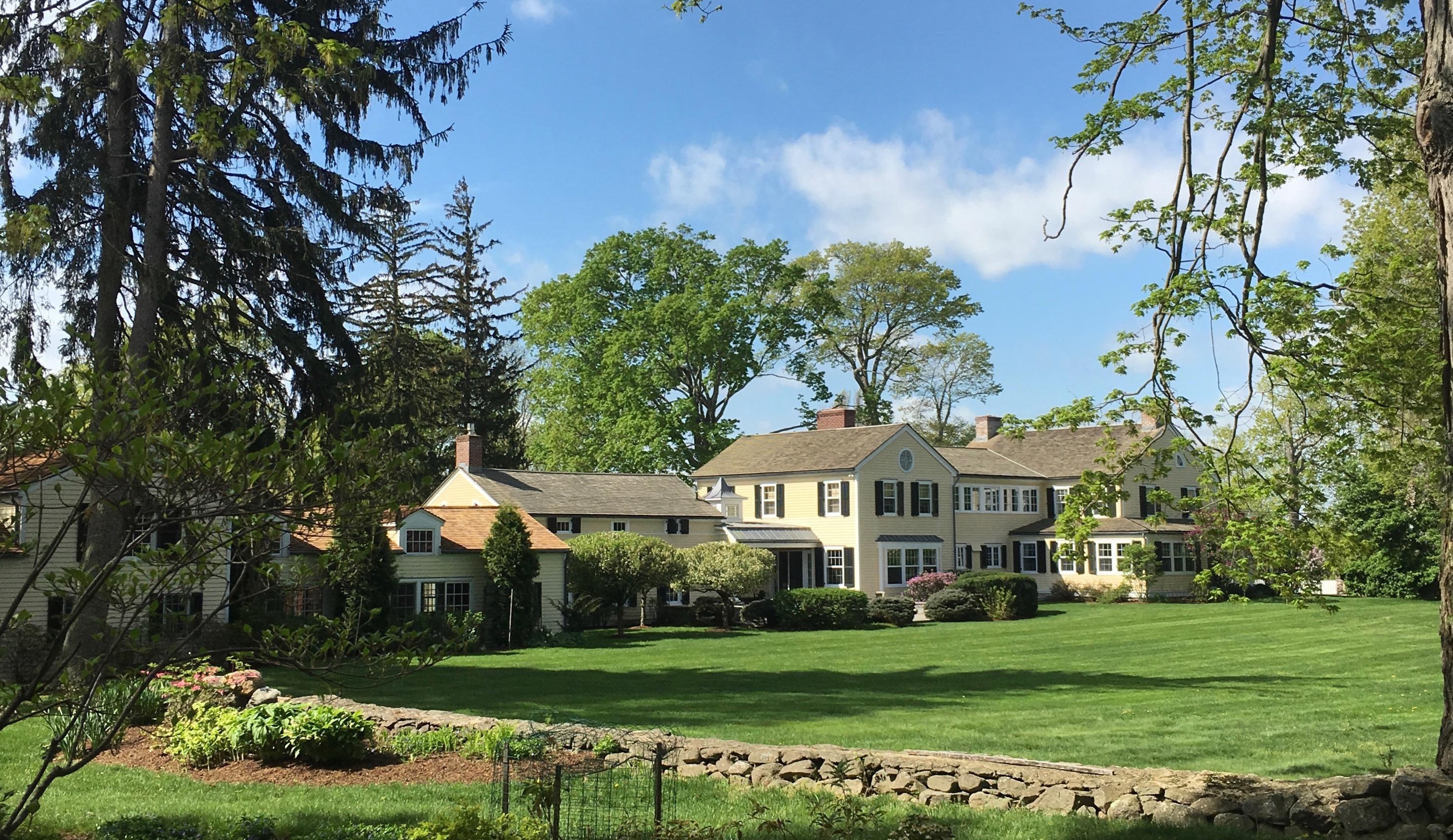 991 Ponus Ridge Road New Canaan, CT 06840 - Photo 1 of 12 a front view of a house with a yard and green space