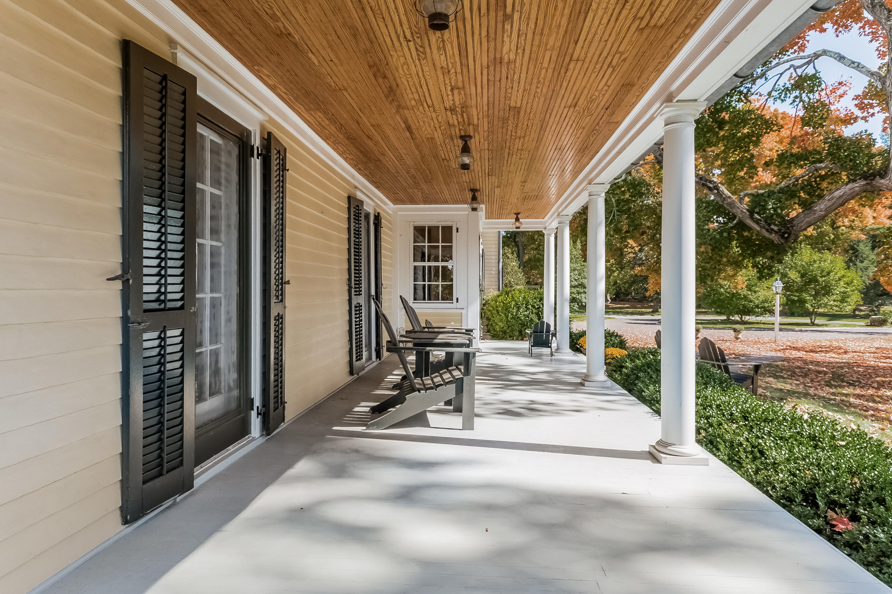 991 Ponus Ridge Road New Canaan, CT 06840 - Photo 3 of 12 a view of a patio with table and chairs and floor to ceiling window with wooden fence