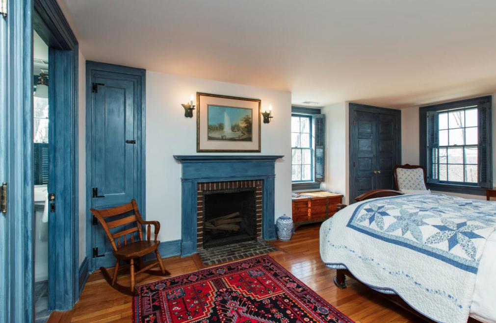 991 Ponus Ridge Road New Canaan, CT 06840 - Photo 8 of 12 a bedroom with a bed and a fireplace