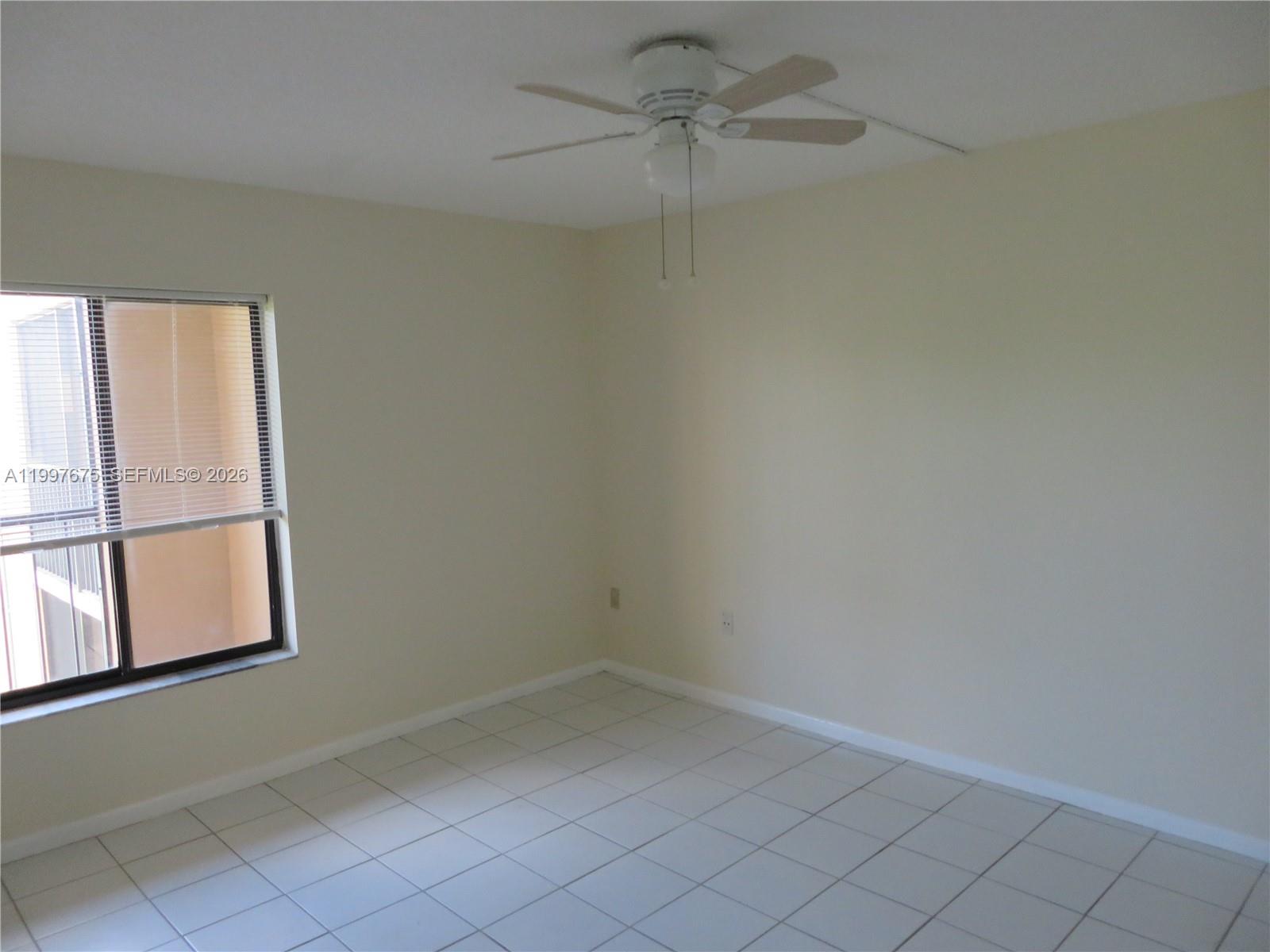 8005 Southwest 107th Avenue, Unit 309 Miami, FL 33173 - Photo 3 of 18 an empty room with windows and fan