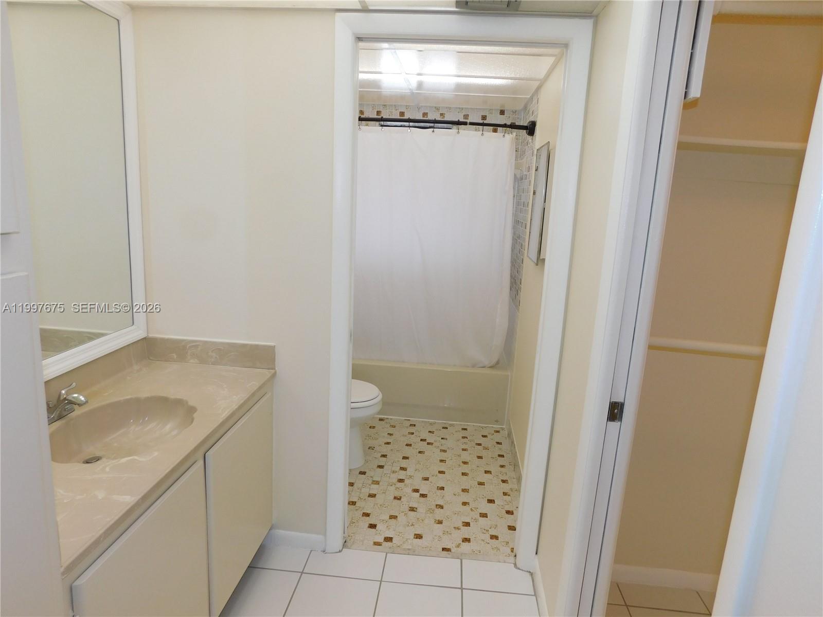 8005 Southwest 107th Avenue, Unit 309 Miami, FL 33173 - Photo 8 of 18 a bathroom with a granite countertop sink a toilet and shower