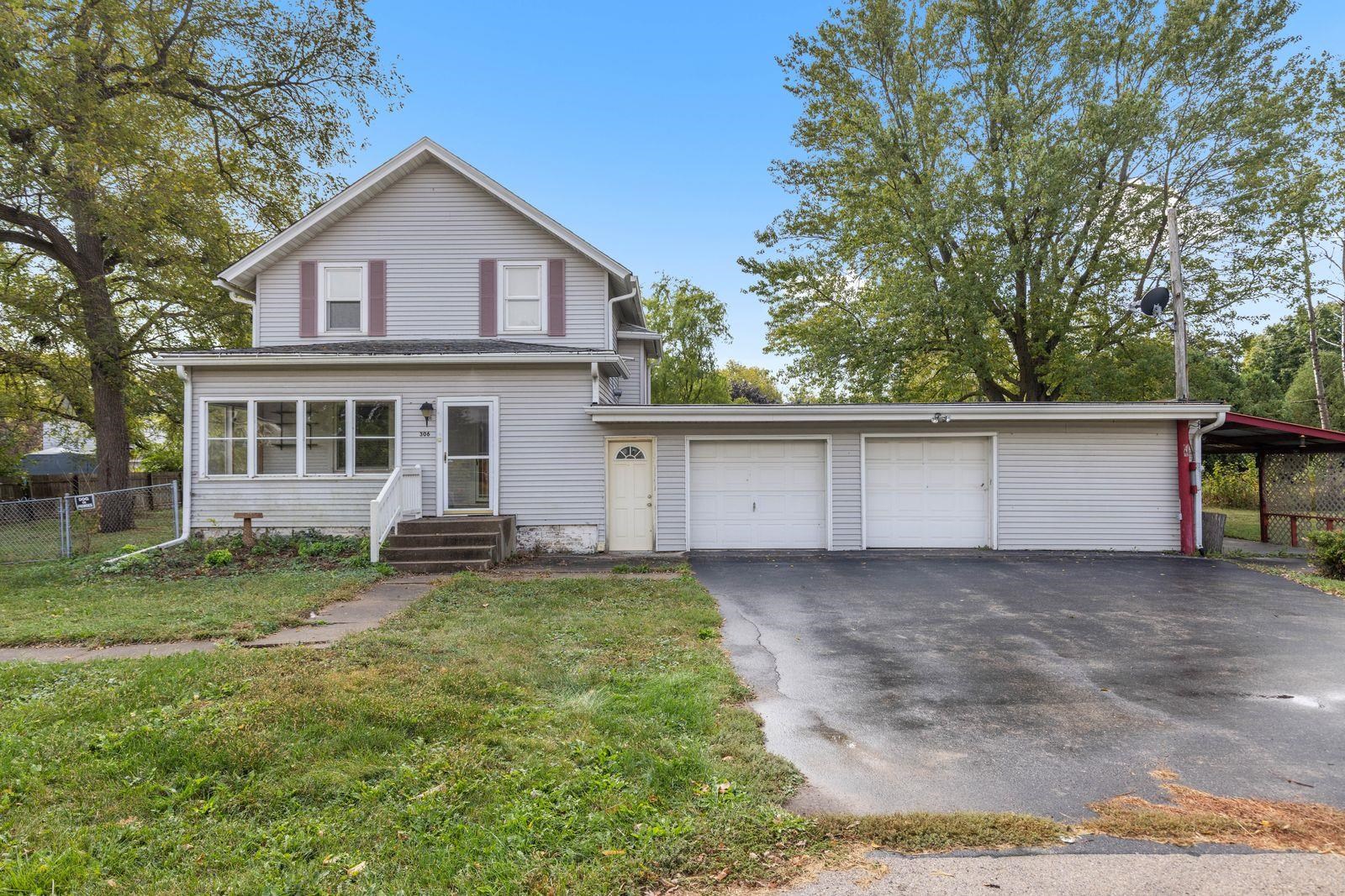 a view of a house with a yard and a large tree