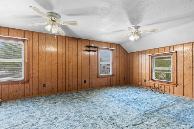 an empty room with windows and fan