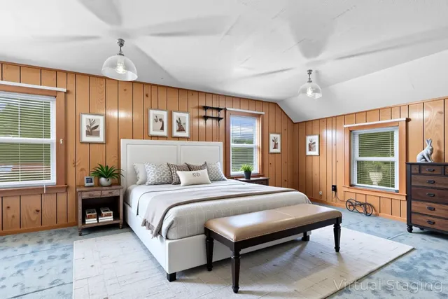 a spacious bedroom with a bed a table and windows