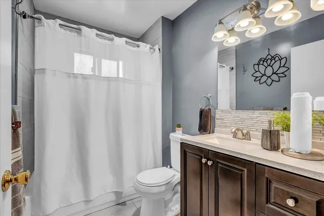 a bathroom with a sink vanity granite and toilet