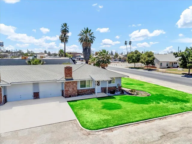 a view of house with yard and outdoor seating