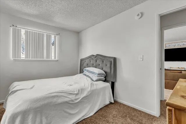 a bedroom with baby bed a couch and a window