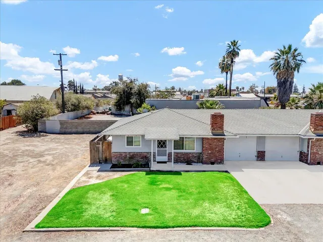 a view of a house with a backyard and patio