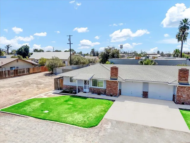 a view of a house with a big yard and potted plants