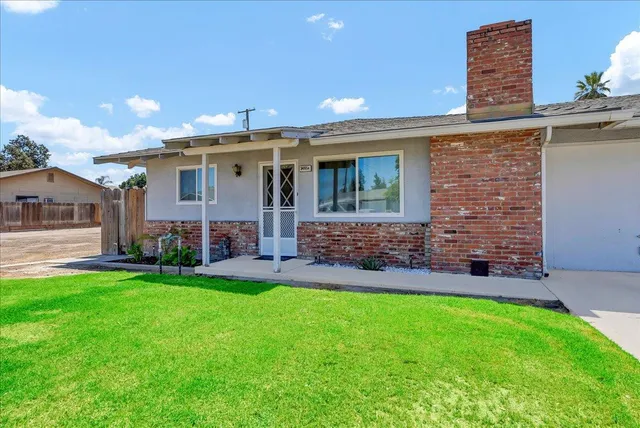 a view of a house with a yard and sitting area