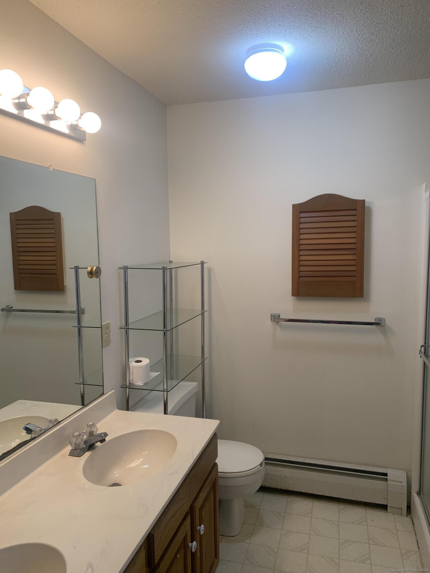58 Amanda Circle Windsor, CT 06095 - Photo 14 of 36 a bathroom with a sink a toilet a mirror and vanity