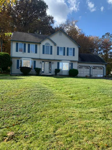 a view of a house with a swimming pool and a yard