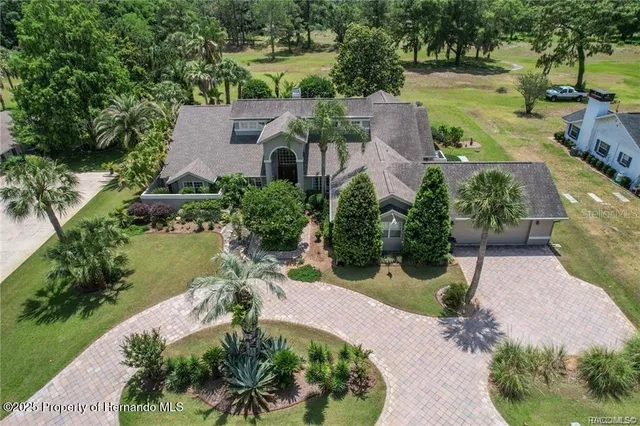 an aerial view of a house with a garden and lake view