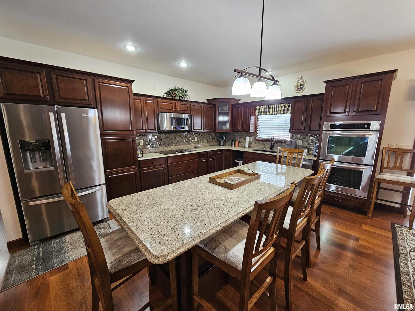 10586 North Spring Garden Lane Mount Vernon, IL 62864 - Photo 21 of 39 a kitchen with stainless steel appliances granite countertop a refrigerator a stove a sink a dining table and chairs