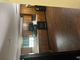 1017 West 3rd Street Taylor, TX 76574 - Photo 9 of 23 a large kitchen with kitchen island granite countertop a sink counter top space and stainless steel appliances