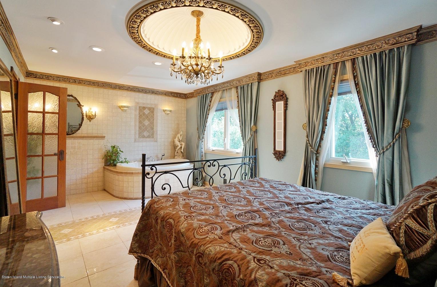 178 Admiralty Loop Staten Island, NY 10309 - Photo 26 of 50 a bedroom with a bed and a chandelier