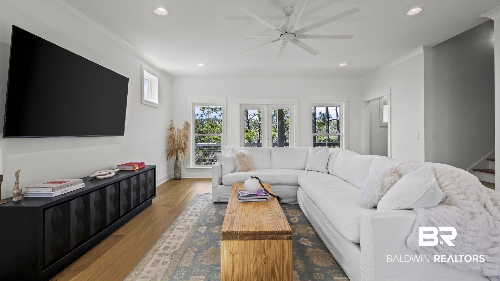 30449 River Road Orange Beach, AL 36561 - Photo 3 of 39 Living room featuring a ceiling fan, wood finished floors, french doors, recessed lighting, and ornamental molding