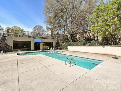 a view of pool with outdoor seating and trees