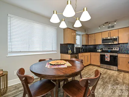 a kitchen with a dining table chairs and stove