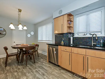 a kitchen with stainless steel appliances granite countertop sink table and chairs
