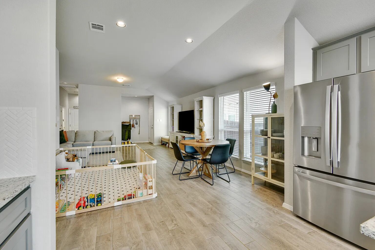 121 Crescent Street Georgetown, TX 78626 - Photo 27 of 27 Kitchen with stainless steel refrigerator with ice dispenser, gray cabinetry, light wood finished floors, lofted ceiling, and open floor plan