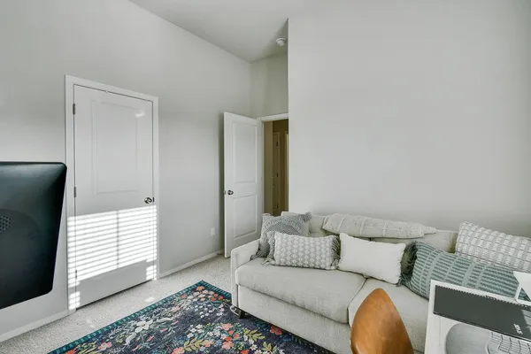 a living room with furniture wooden floor and a refrigerator