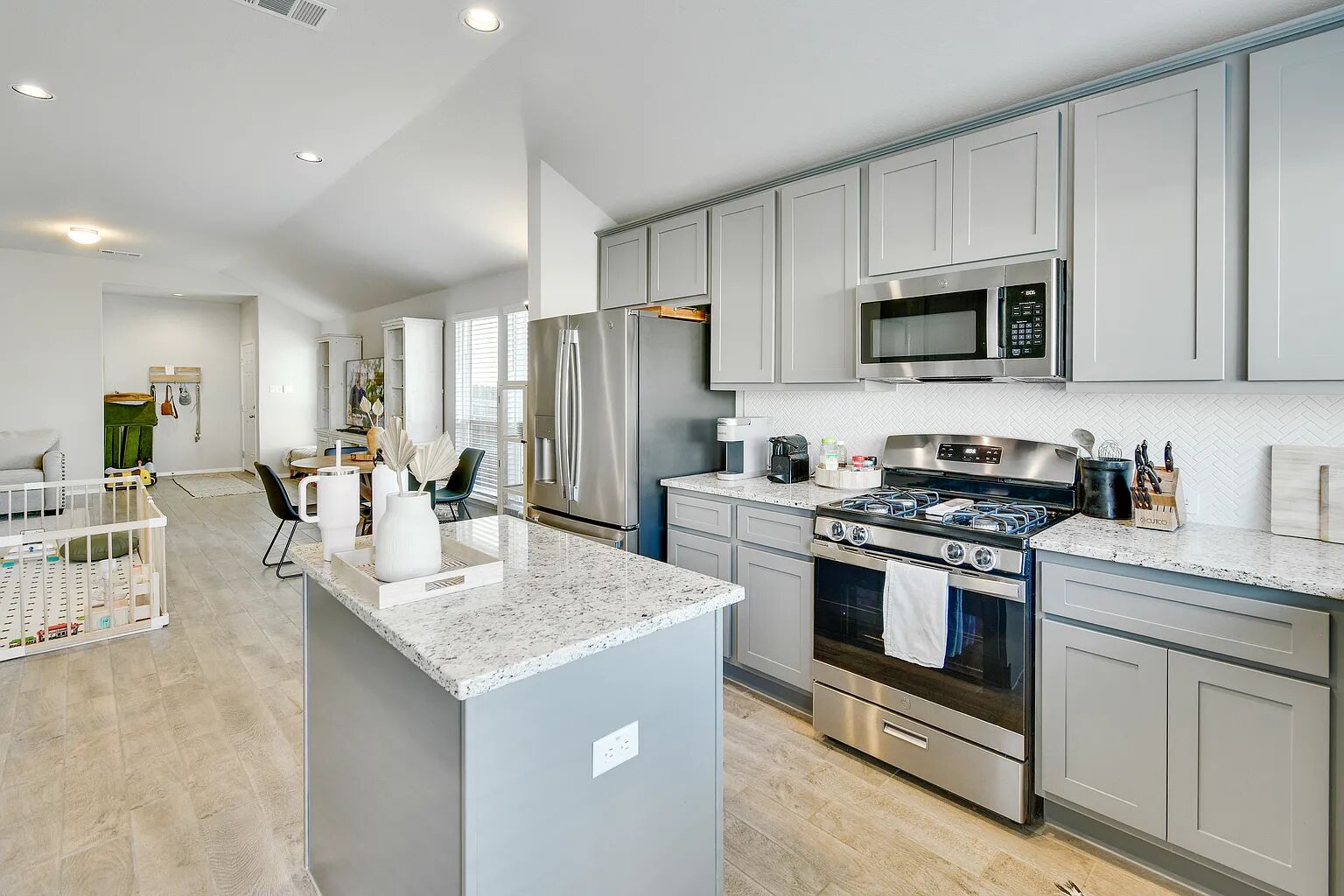 121 Crescent Street Georgetown, TX 78626 - Photo 26 of 27 Kitchen featuring gray cabinets, open floor plan, stainless steel appliances, light stone counters, and recessed lighting