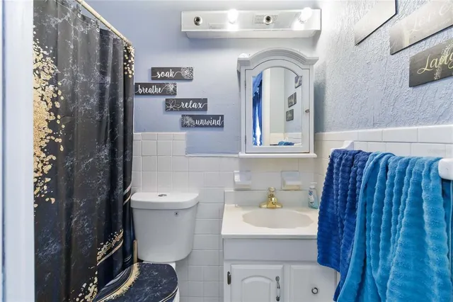 a bathroom with a toilet sink and mirror