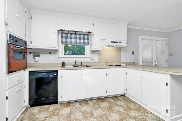 a kitchen with granite countertop white cabinets and white appliances